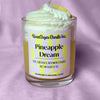Candle labeled 'Pineapple Dream' with a pineapple slice on a purple background