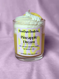Candle labeled 'Pineapple Dream' with a pineapple slice on a purple background
