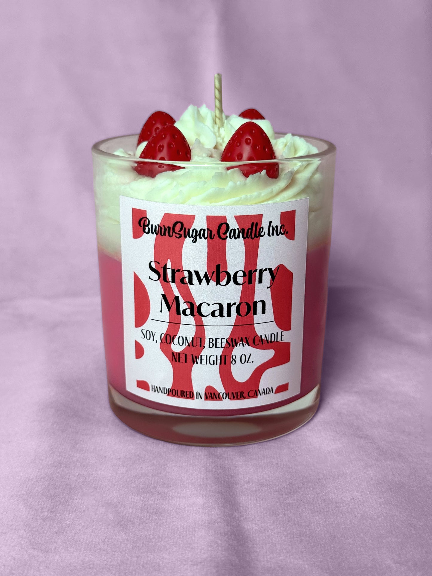 Strawberry Macaron candle with strawberry toppings on a purple background