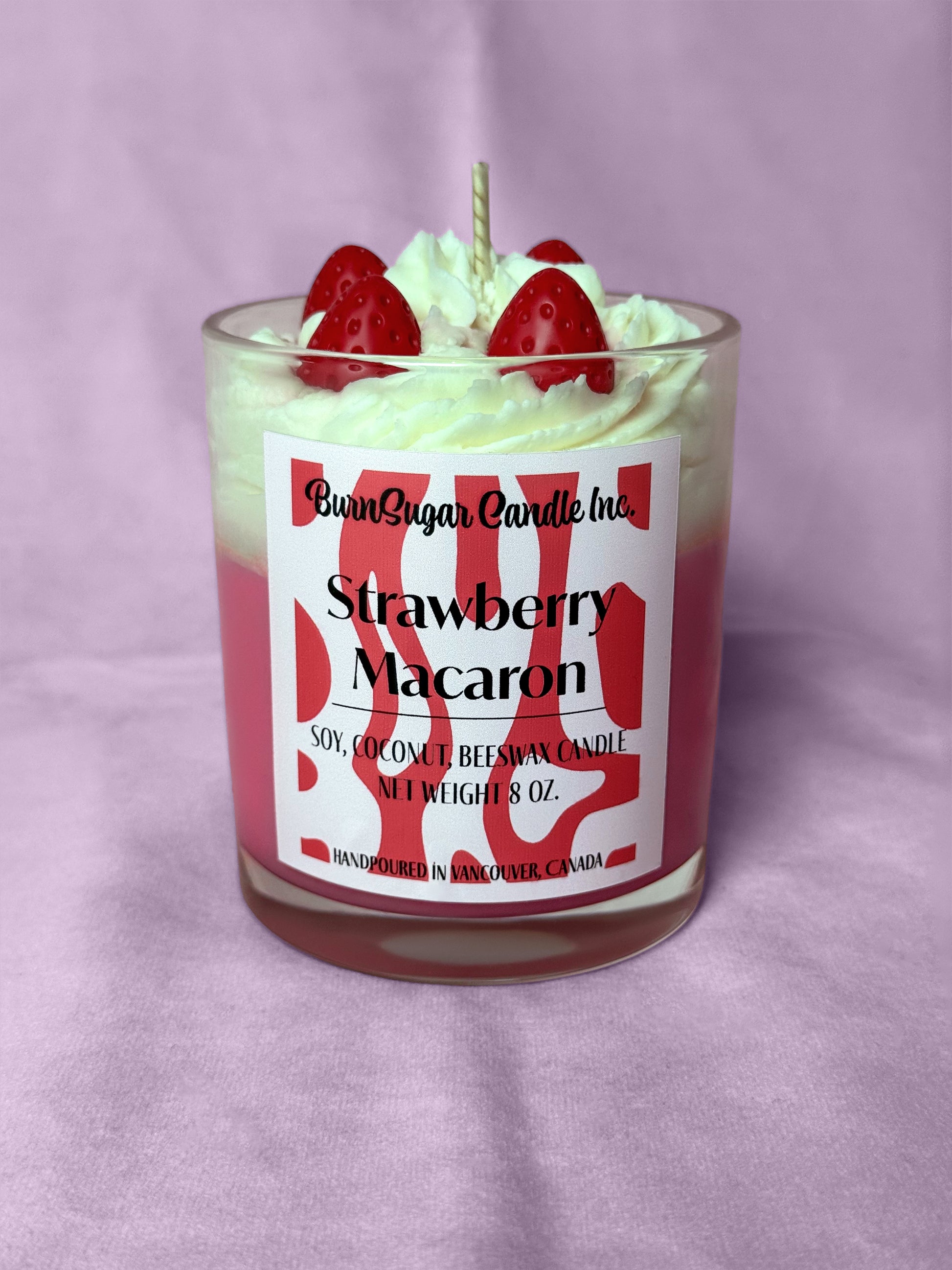 Strawberry Macaron candle with strawberry toppings on a purple background