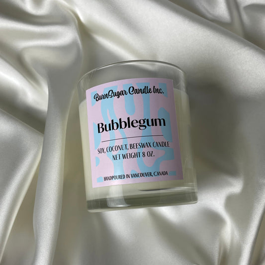 Candle labeled 'Bubblegum' on a satin fabric background
