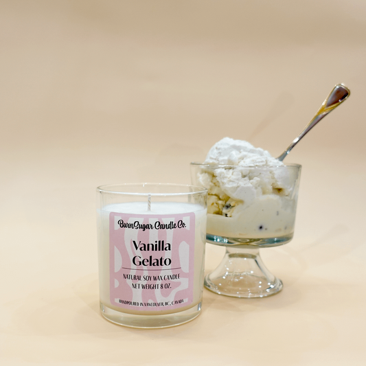 This image showcases a "Vanilla Gelato" soy wax candle from BurnSugar Candle Inc., displayed alongside a dessert-style bowl of what appears to be vanilla gelato with a spoon. The setup creates a cohesive aesthetic between the product and its fragrance theme. 